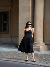 A woman wears a little black dress